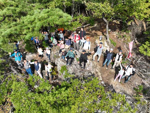 八丈岩に着いた登山者をドローンが空撮