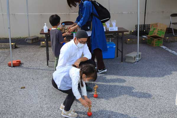 けん玉遊びを教える男性と子供