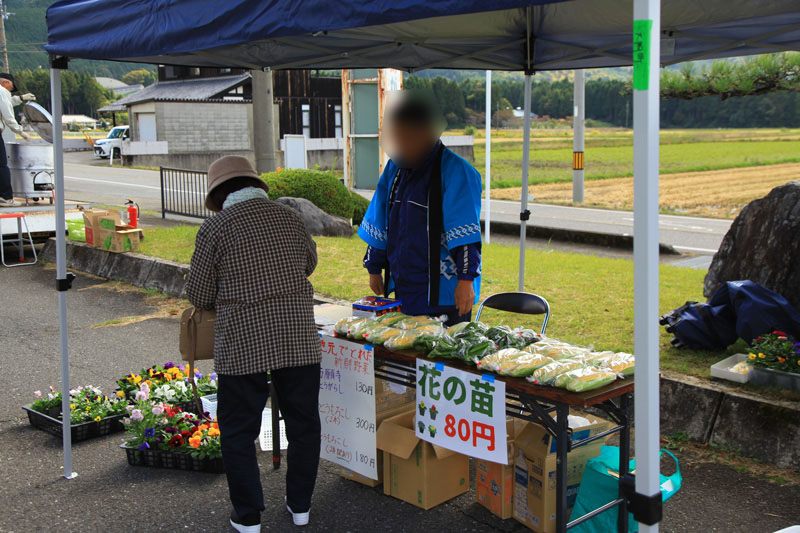 出展ブースで野菜を買う女性