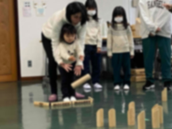 保護者の力を借りてモルックを投げる未就学児