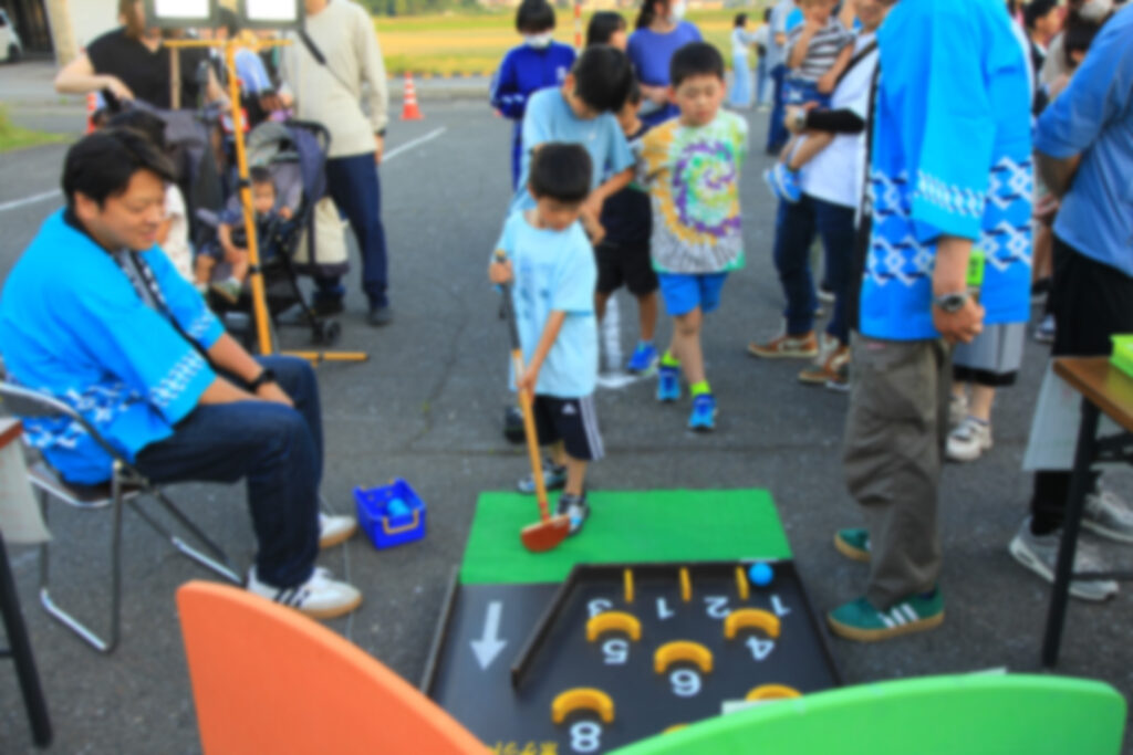 ほたる祭り2025のボール転がしゲームをする子ども