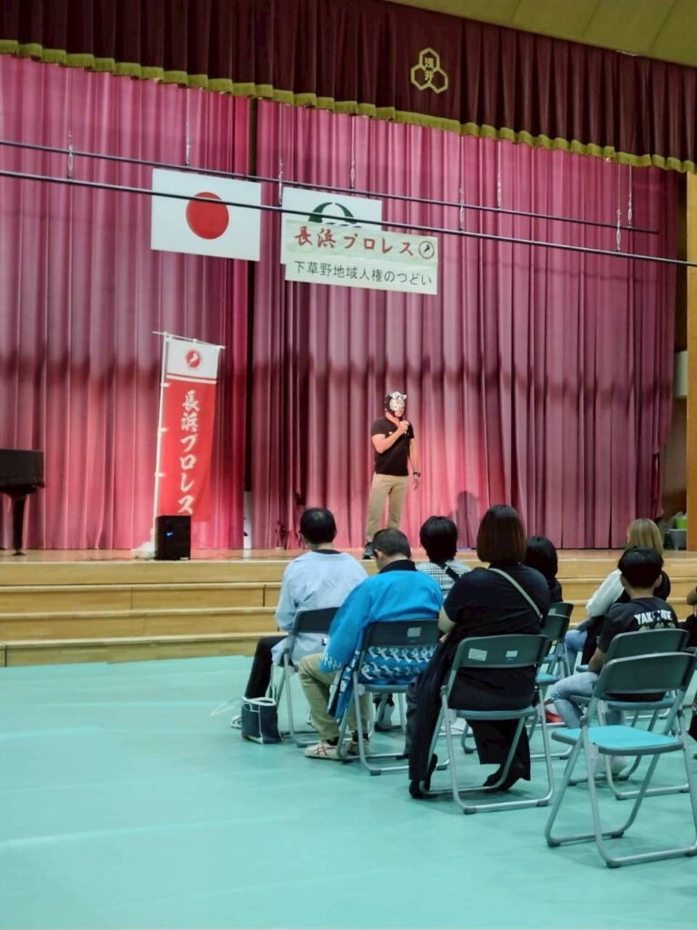レスラーが人権のつどいの講演をしている