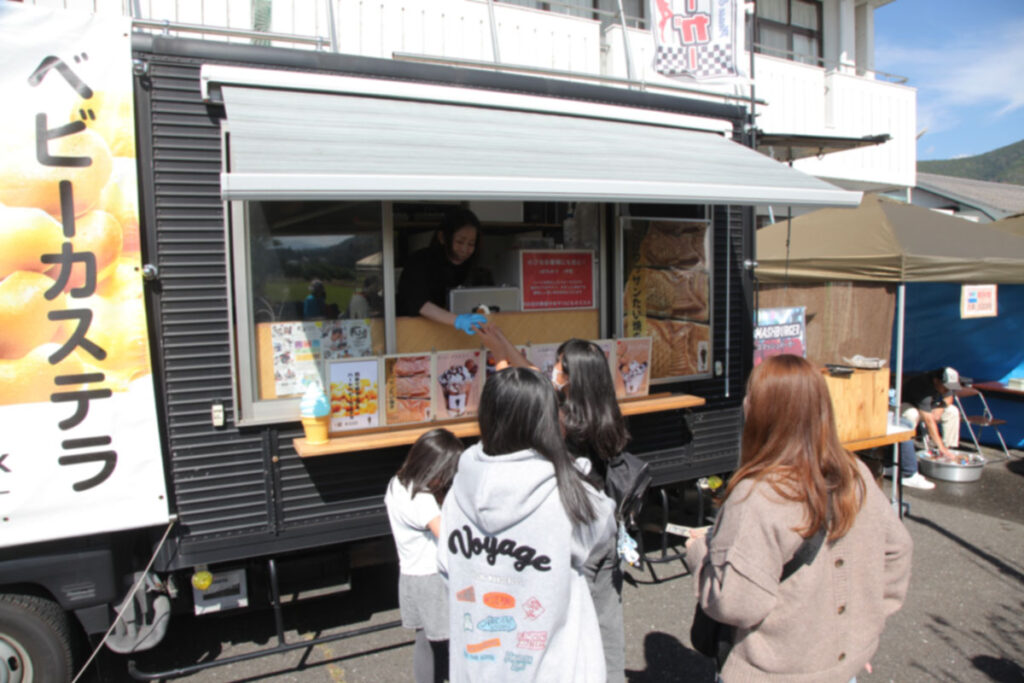 キッチンカーで買い物をする女の子