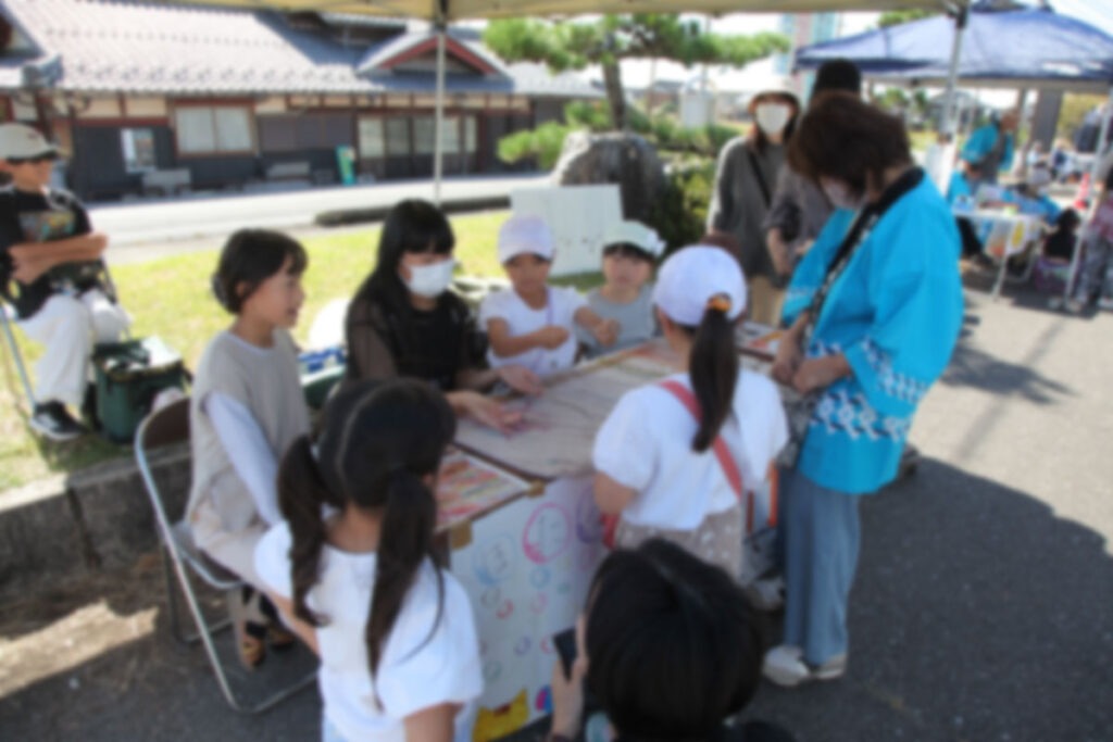 学童保育に通う子供たちの手作りミサンガの売店で買い物をする子供たち